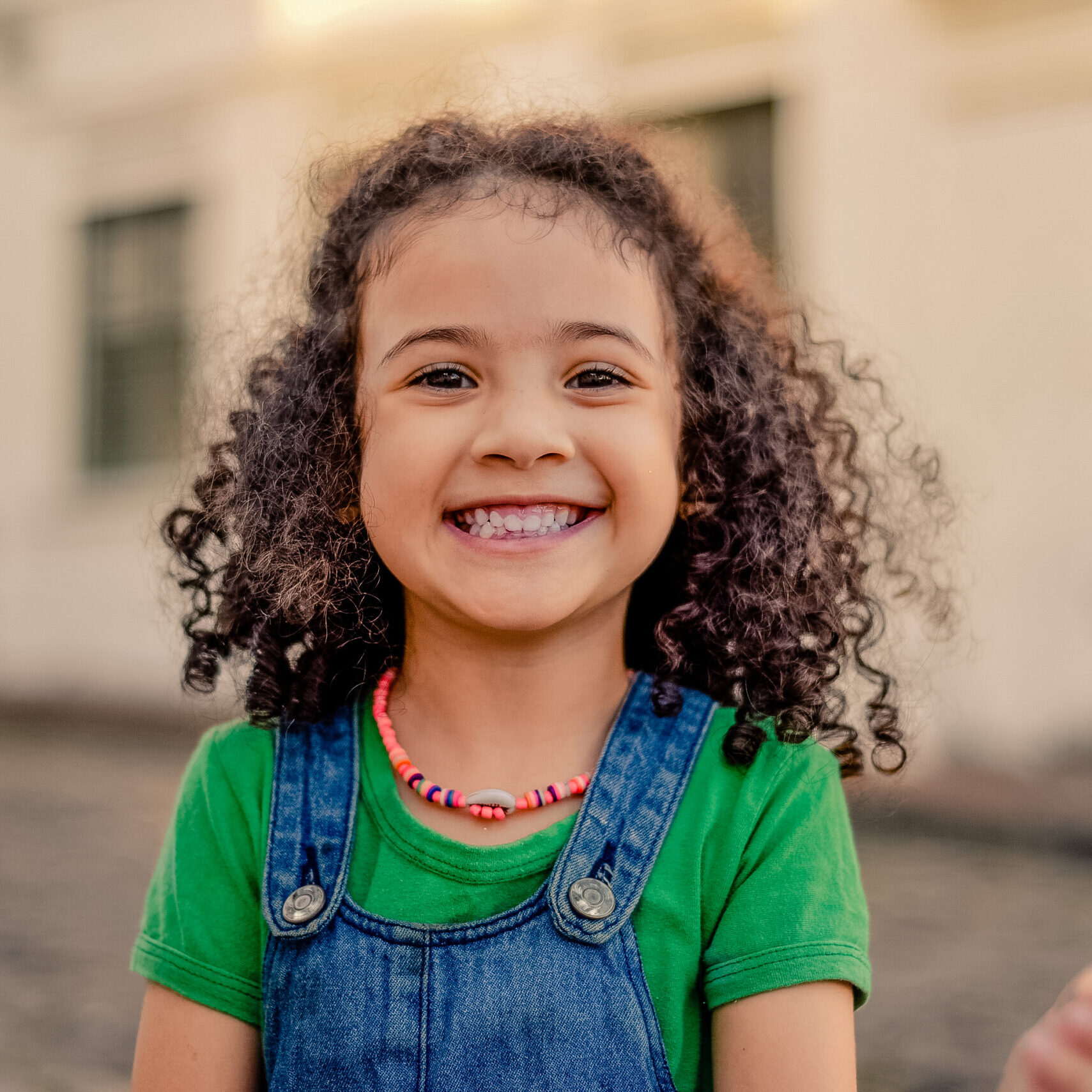 Small girl smiling on the street. looking at the camera